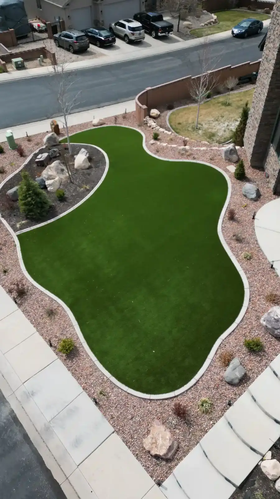 Aerial view of a curved turf lawn surrounded by rock landscaping