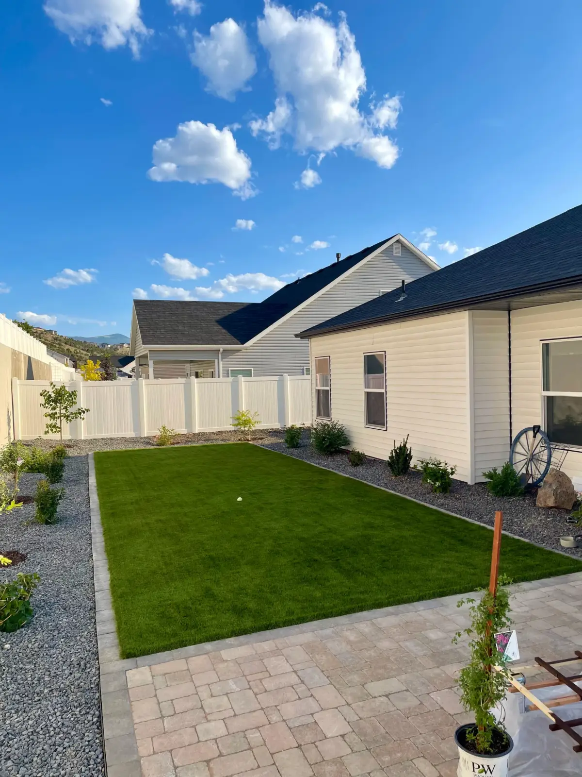 Backyard turf lawn with white vinyl fence