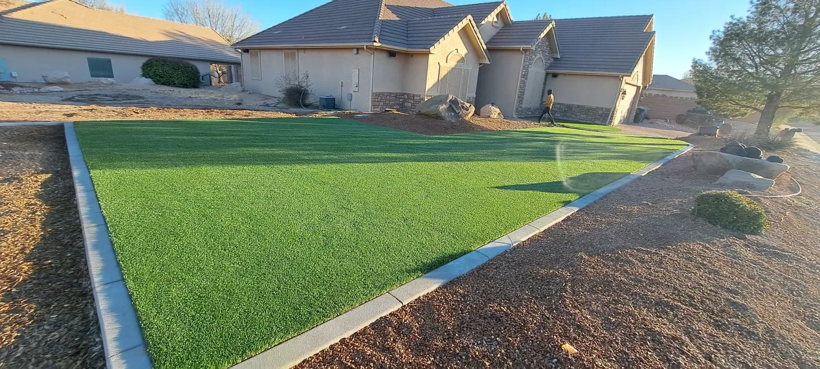 Front yard turf with concrete border and rock bed