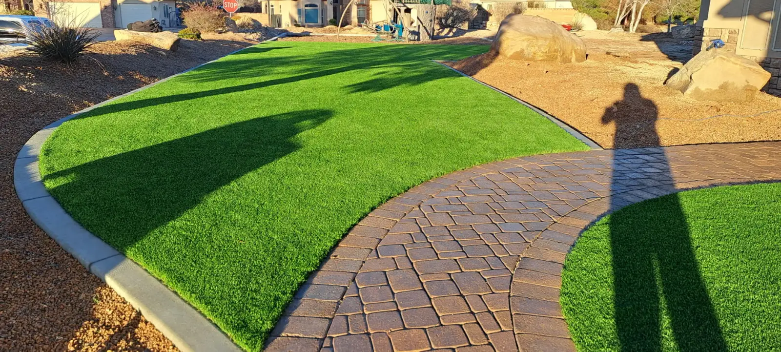 Artificial turf lawn beside a paver walkway